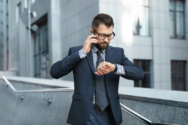 Cep telefonu açık havada üzerinde konuşurken yakışıklı başarılı iş adamı