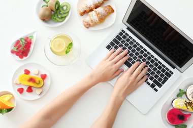Gıda blogger laptop ve beyaz masa üzerinde farklı ürünleri ile eller