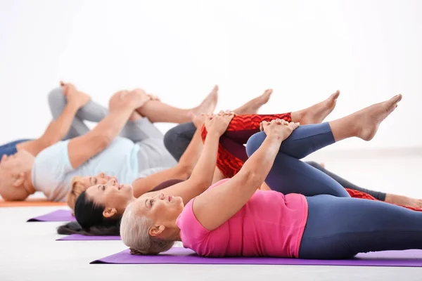Group of mature men and women at yoga lesson indoors — Stock Photo, Image