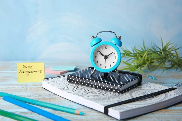 Time management concept. Composition with alarm clock on wooden table