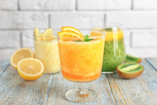 Gläser mit verschiedenen Smoothies auf dem Tisch gegen Ziegelwand — Stockfoto