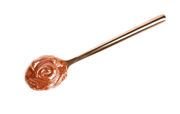 Cucchiaio con deliziosa salsa al caramello su sfondo bianco — Foto Stock