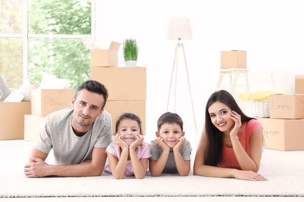 Op vloer nieuwe thuis liggen en gelukkige familie — Stockfoto