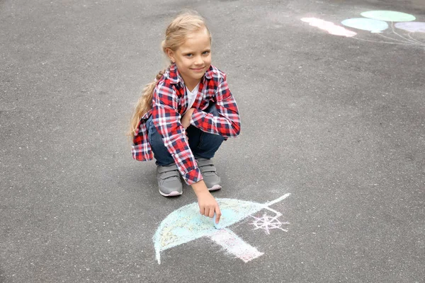 Little girl drawing ship with chalk on asphalt — Stock Photo, Image