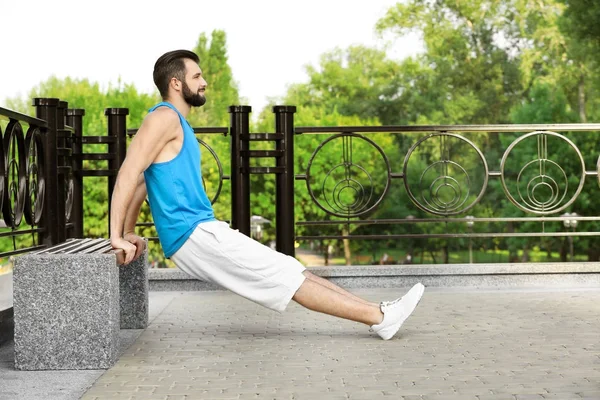 Handsome young man exercising in park — Stock Photo, Image