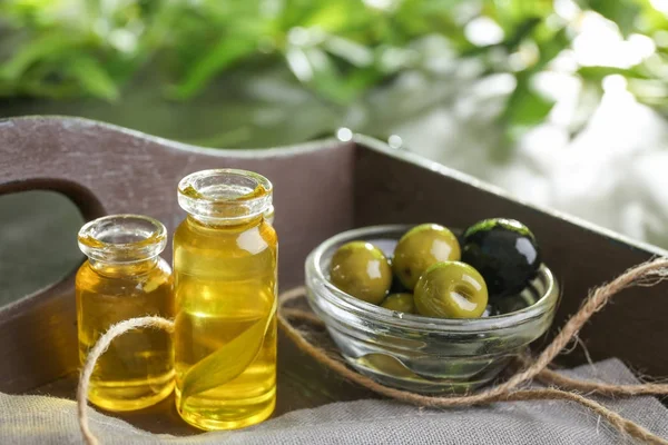 Bottles with olive oil on wooden tray — Stock Photo, Image