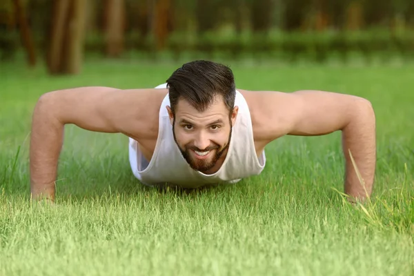 Yakışıklı genç adam parkta egzersiz