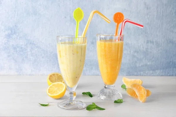 Glasögon med olika smoothies på bordet mot ljus bakgrund — Stockfoto