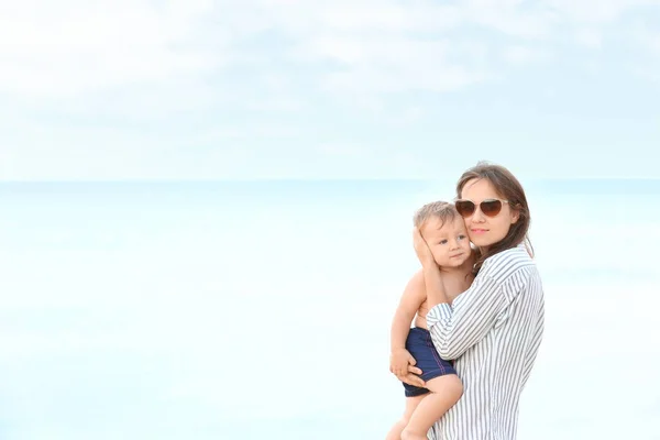 Glückliche Mutter mit kleinem Sohn am Strand — Stockfoto