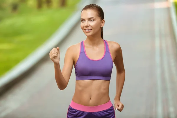 Giovane donna sportiva che corre nel parco — Foto Stock