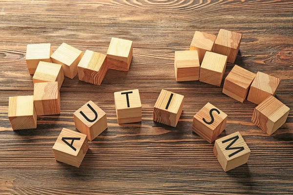 Cubes with word AUTISM on wooden background