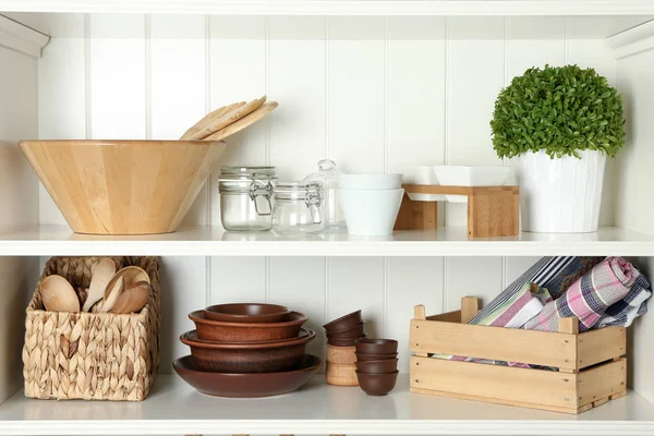 Verschillende keukengerei op planken — Stockfoto
