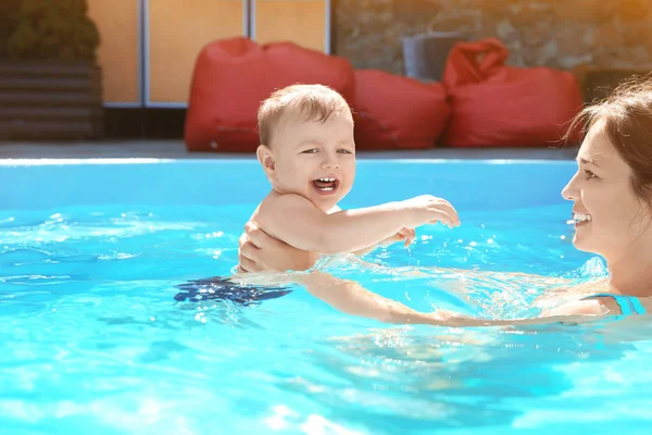 Gyermek medence leckét. Aranyos kisfiú megtanulni úszni, anya a medence — Stock Fotó