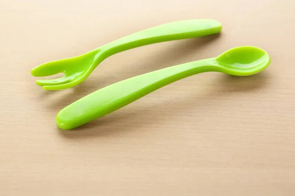 Utensilios de alimentación coloridos para bebé en mesa de madera —  Fotos de Stock