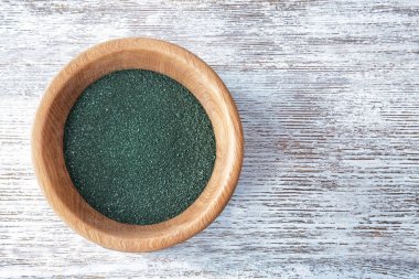 Spirulina toz kase ahşap arka plan üzerinde