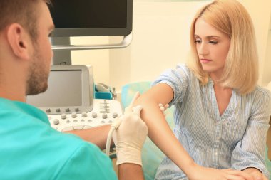 Hastanın dirsek iletken ultrason muayenesi kliniğinde doktor