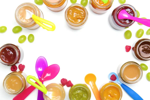 Vasi con diversi alimenti per bambini e cucchiai su sfondo bianco — Foto Stock