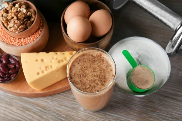 Zusammensetzung mit Proteinshake, Pulver und Lebensmitteln auf dem Tisch — Stockfoto