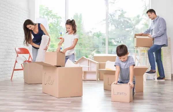 Gelukkige familie uitpakken bewegende vakken op kamer nieuwe thuis — Stockfoto