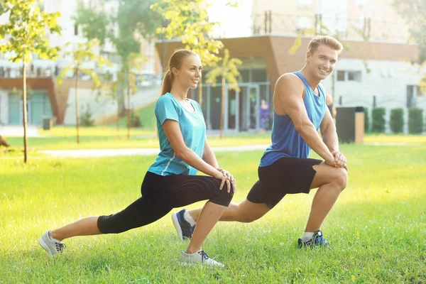 Joven pareja deportiva haciendo ejercicio en parque verde — Foto de Stock