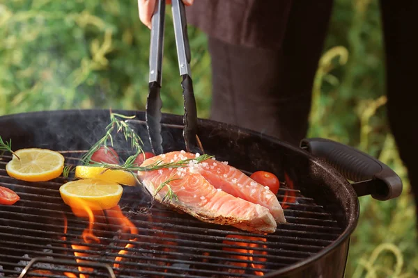 Mujer cocinando filete en la parrilla barbacoa — Foto de Stock