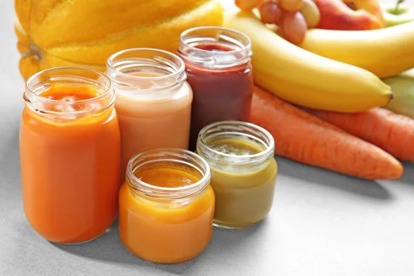 Jars with different baby food and ingredients on table — Stock Photo, Image