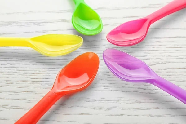 Colorful eating utensils for baby on wooden table — Stock Photo, Image
