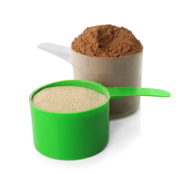 Scoops with protein powder on white background