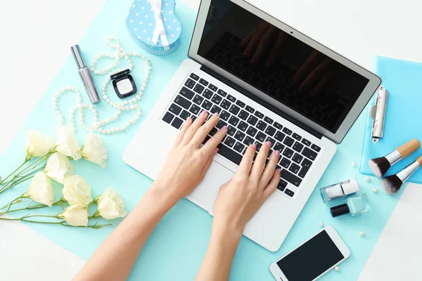 Mani di bellezza blogger con computer portatile e cose diverse sul tavolo — Foto Stock