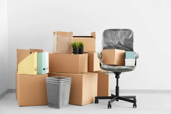 Conceito de mudança de escritório. Caixas de papelão e cadeira no chão em quarto vazio — Fotografia de Stock