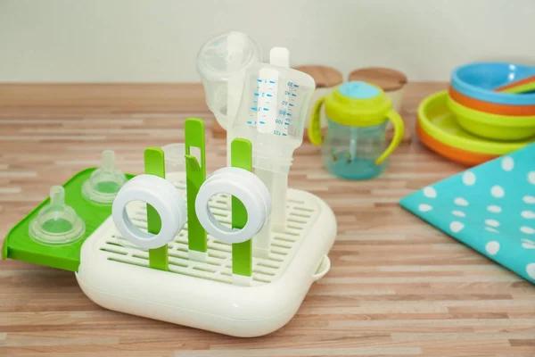 Drier with baby bottles on table — Stock Photo, Image