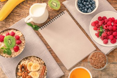 Lezzetli yulaf ezmesi ve ahşap arka plan üstünde defter ile kompozisyon