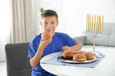 Geleneksel sufganiyah evde ile Yahudi çocuk