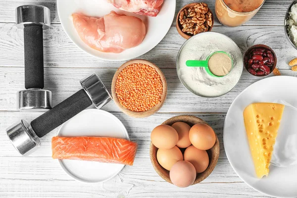 Composizione con alimenti ricchi di proteine e polvere su fondo di legno — Foto Stock