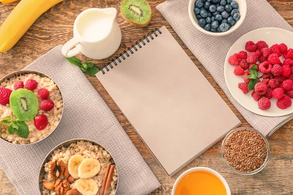 Lezzetli yulaf ezmesi ve ahşap arka plan üstünde defter ile kompozisyon