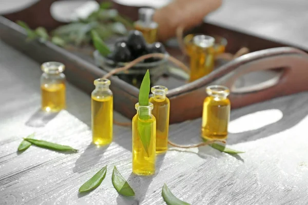 Flessen met olijfolie op houten tafel — Stockfoto