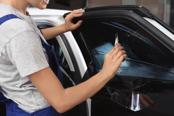 Female worker tinting car window — Stock Photo, Image