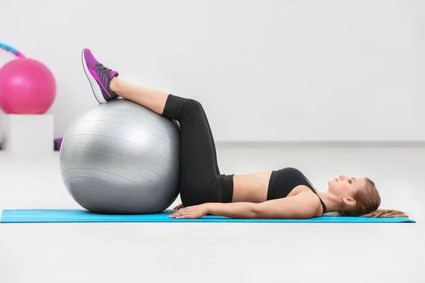 Mulher bonita com treinamento de bola de fitness no ginásio — Fotografia de Stock