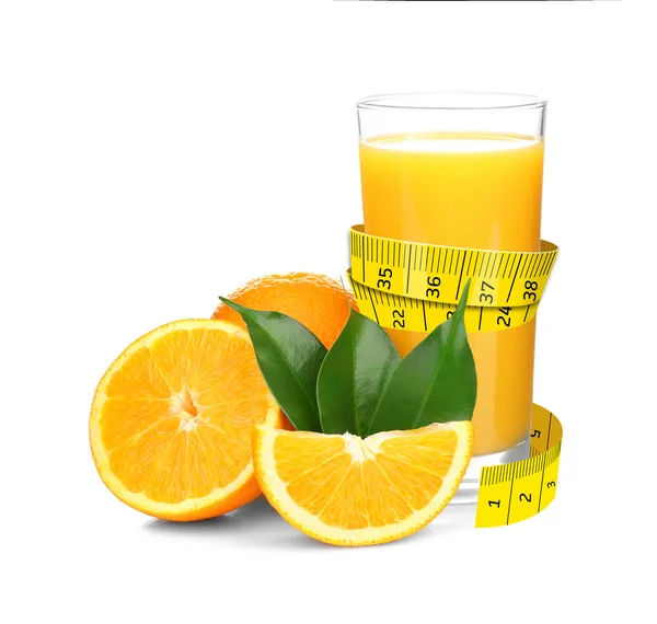 Měřicí pásky a pomerančový džus ve skle s nakrájeným ovocem pro hubnutí — Stock fotografie