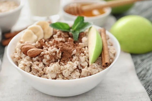 Tasty oatmeal in bowl for breakfast, close up — Stock Photo, Image