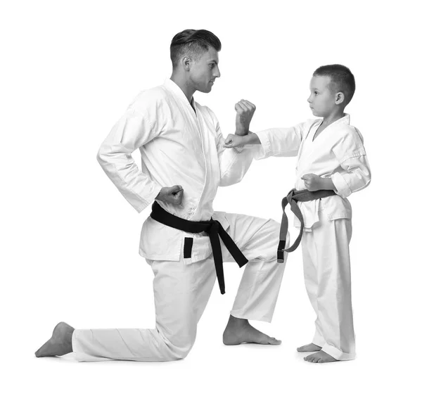 Niño pequeño con profesor practicando karate sobre fondo blanco — Foto de Stock