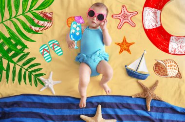 Kumaş arka plan üzerinde yalan güneş gözlüklü şirin bebek