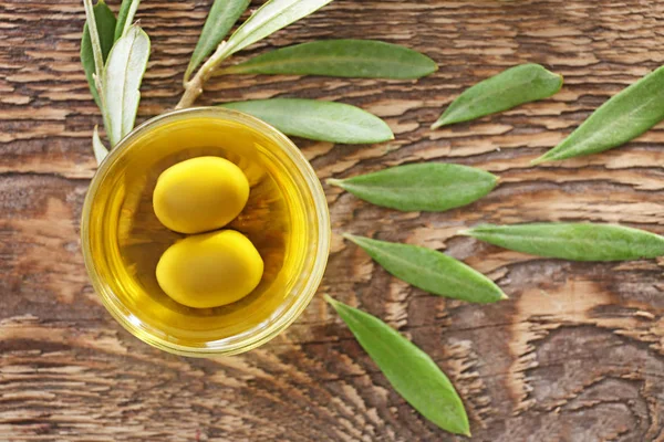 Miska z oliwy z oliwek na drewnianym stole — Zdjęcie stockowe