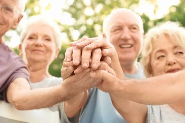 Grupp äldre människor att sätta händerna ihop som symbol för enighet — Stockfoto