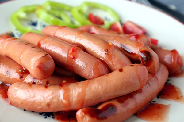 Delicious grilled sausages on plate — Stock Photo, Image