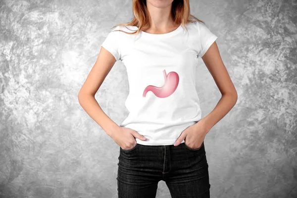 Jeune femme avec illustration de l'estomac sur fond de grunge. Concept de cancer — Photo