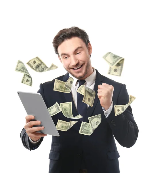 Money flying out of tablet while man using it on white background — Stock Photo, Image