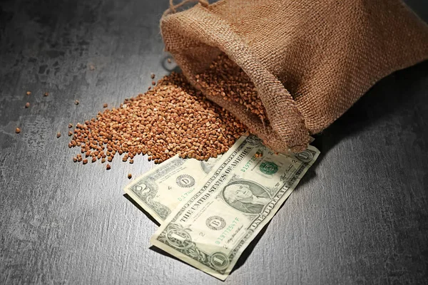 Grano saraceno crudo e denaro in tavola — Foto Stock