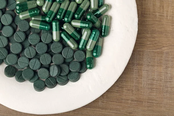 Piatto con Spirulina capsule e compresse — Foto Stock