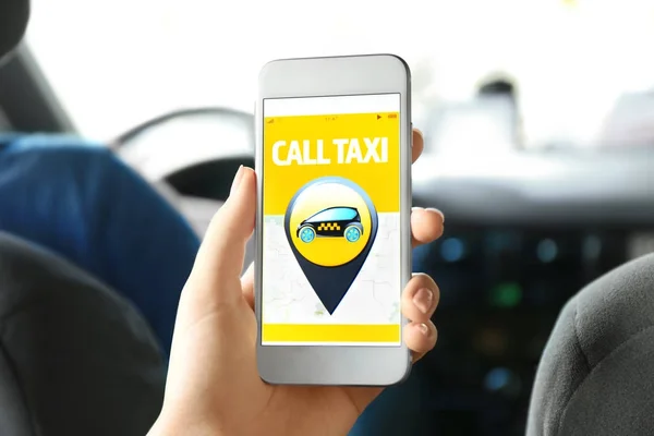 Young woman using cellphone in taxi — Stock Photo, Image